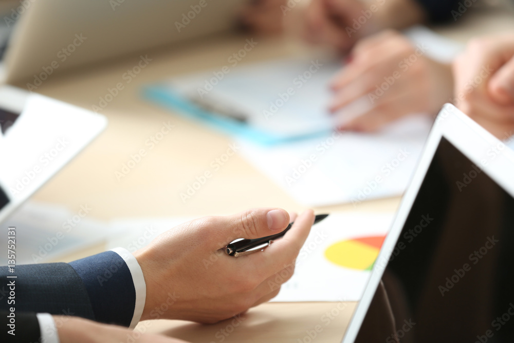Businessman holding pen during meeting in office Businessman holding pen during meeting in office