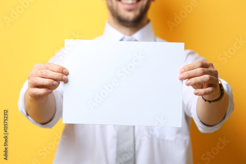 Young man posing with paper...
