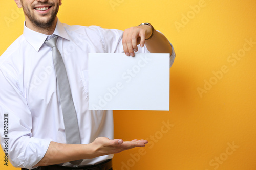Young man posing with paper...