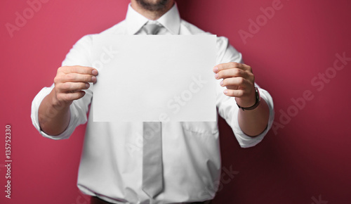 Young man posing with paper...