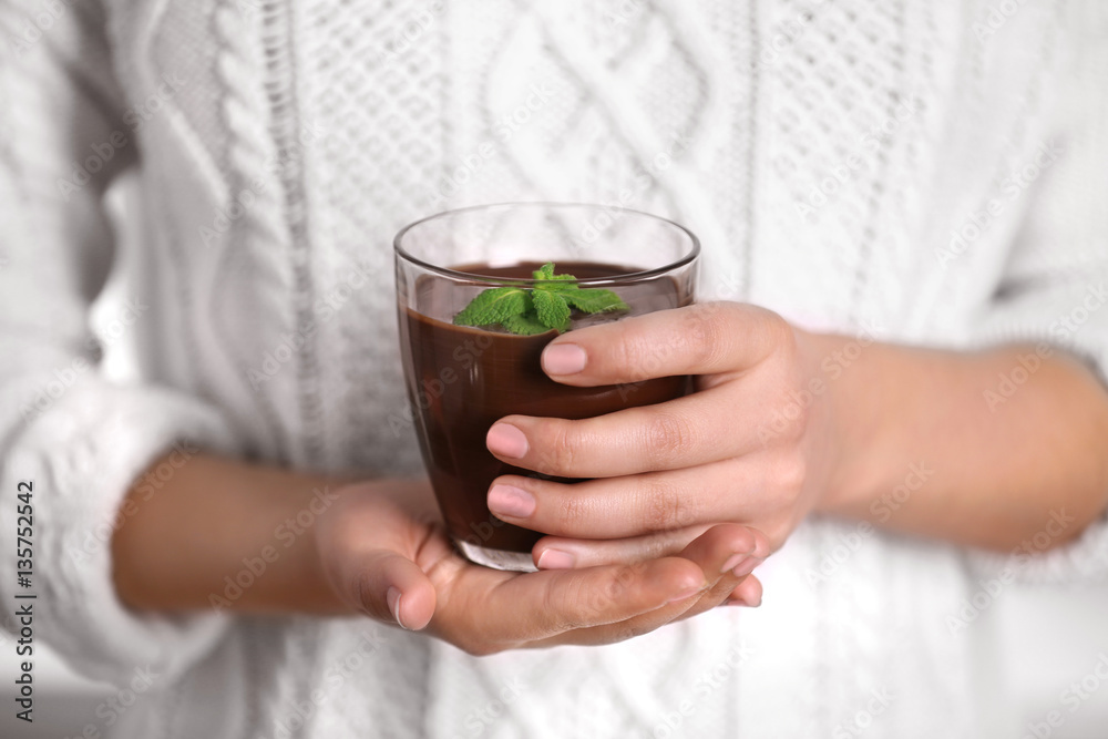 Woman holding glass cup with chocolate mousse, closeup Woman holding glass cup with chocolate mousse, closeup