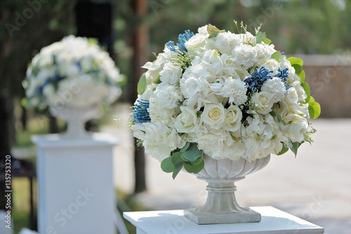 Beautiful wedding bouquet in stone vase closeup, outdoors photo