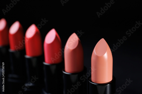 Many lipsticks on dark background