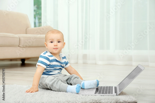 Cute baby boy with laptop o...