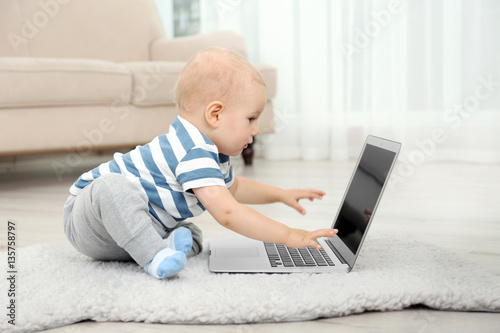 Cute baby boy with laptop o...