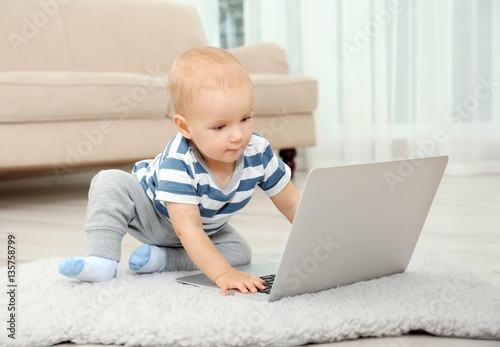 Cute baby boy with laptop o...