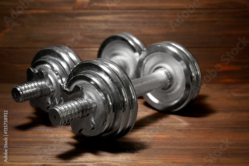 Metal collapsible dumbbells on wooden background