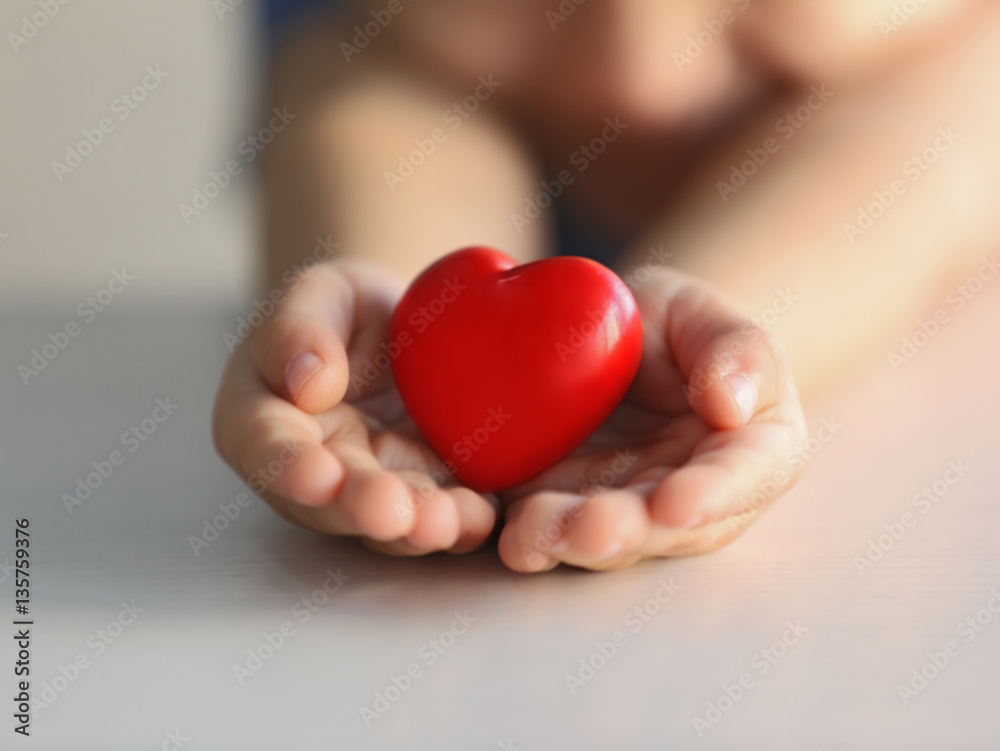 Child holding small red heart, closeup. Adoption concept Child holding small red heart, closeup. Adoption concept