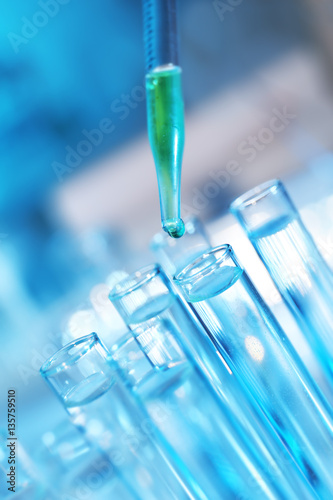 Pipette dropping a sample into a test tube, closeup