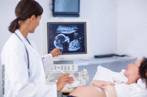 Doctor doing ultrasound for pregnant woman photo