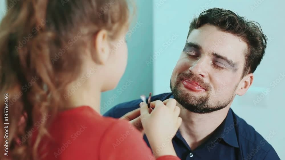 Funny family. Father and his child daughter girl paints lips and eyes to her father. Close-up view. Funny family. Father and his child daughter girl paints lips and eyes to her father. Close-up view.