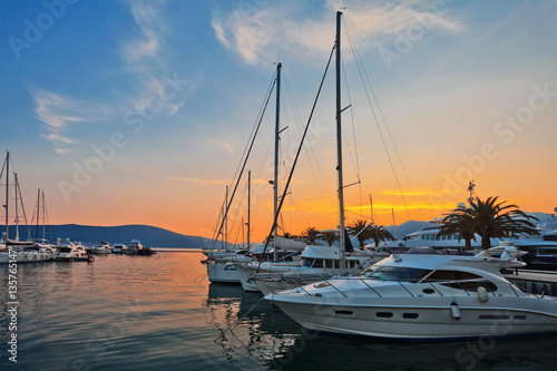 Sailing boats in marina at sunset.