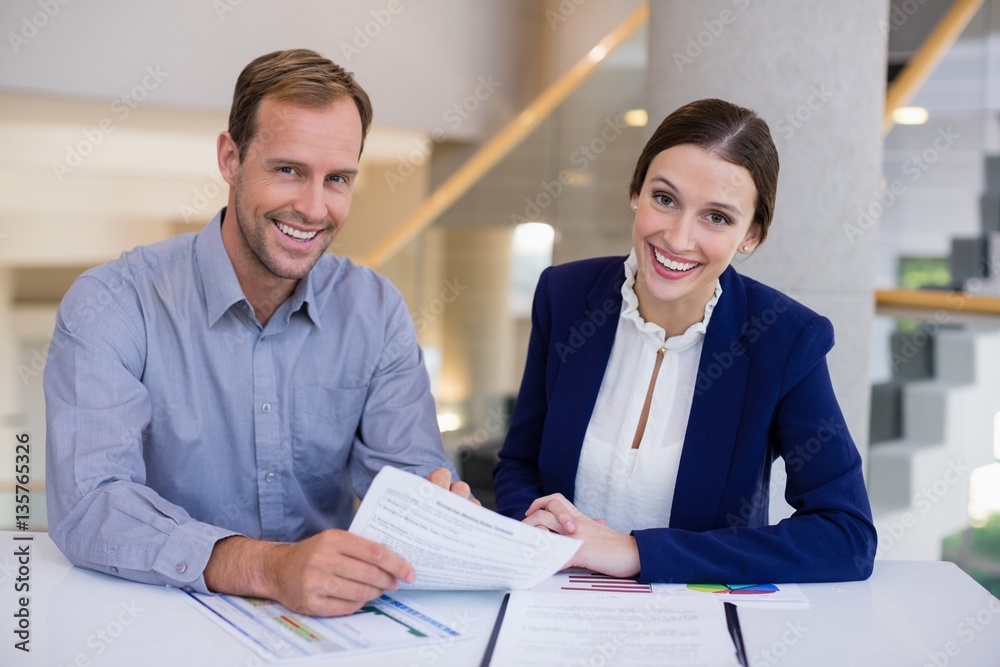 Businesswoman working at desk with colleague Businesswoman working at desk with colleague