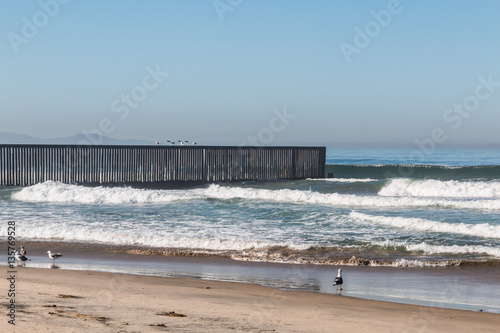 An empty beach at Border Field State Park  with the international border separating San Diego  California from Tijuana  Mexico in the background.