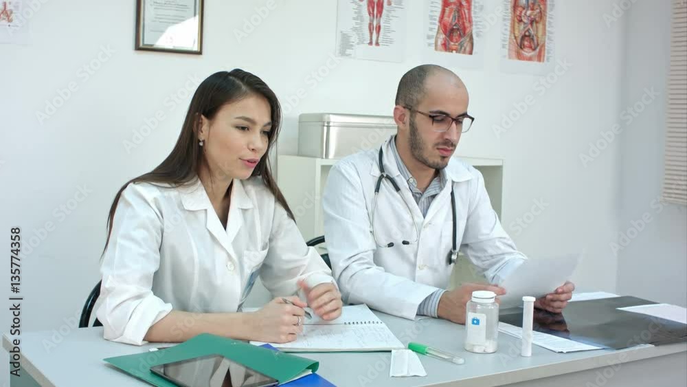 Pretty nurse and male doctor talking to the patient Pretty nurse and male doctor talking to the patient