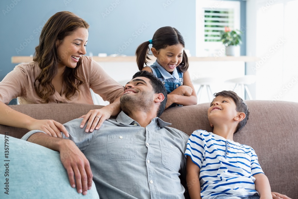 Fototapeta premium Parents and kids interacting on sofa in living room