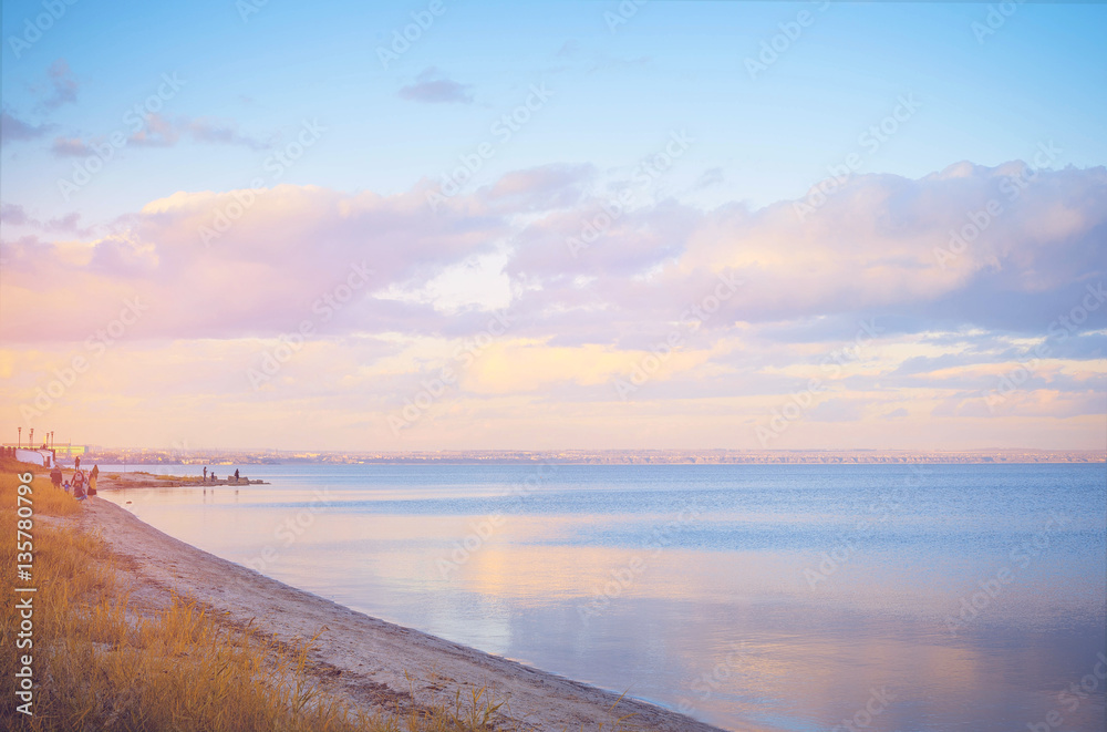 Sky background on sunset, seafront. Nature composition. Panoramic sunset sky background. Taganrog Bay, Azov sea. Beautiful sunset over sea with reflection in water, majestic clouds in the sky. Sky background on sunset, seafront. Nature composition. Panoramic sunset sky background. Taganrog Bay, Azov sea. Beautiful sunset over sea with reflection in water, majestic clouds in the sky.