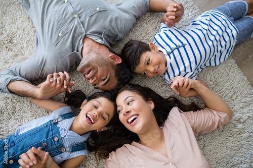 Happy family interacting while lying on rug
