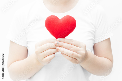 Woman holding and protecting a red heart shape on white background close-up Symbol of love or dating Valentines day