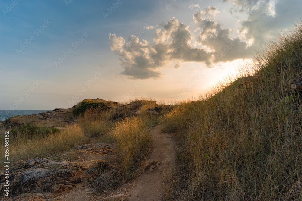 Path through sand dunes leading to beach, with sunset in Khao Laem Ya National Park, Rayong, Thailand