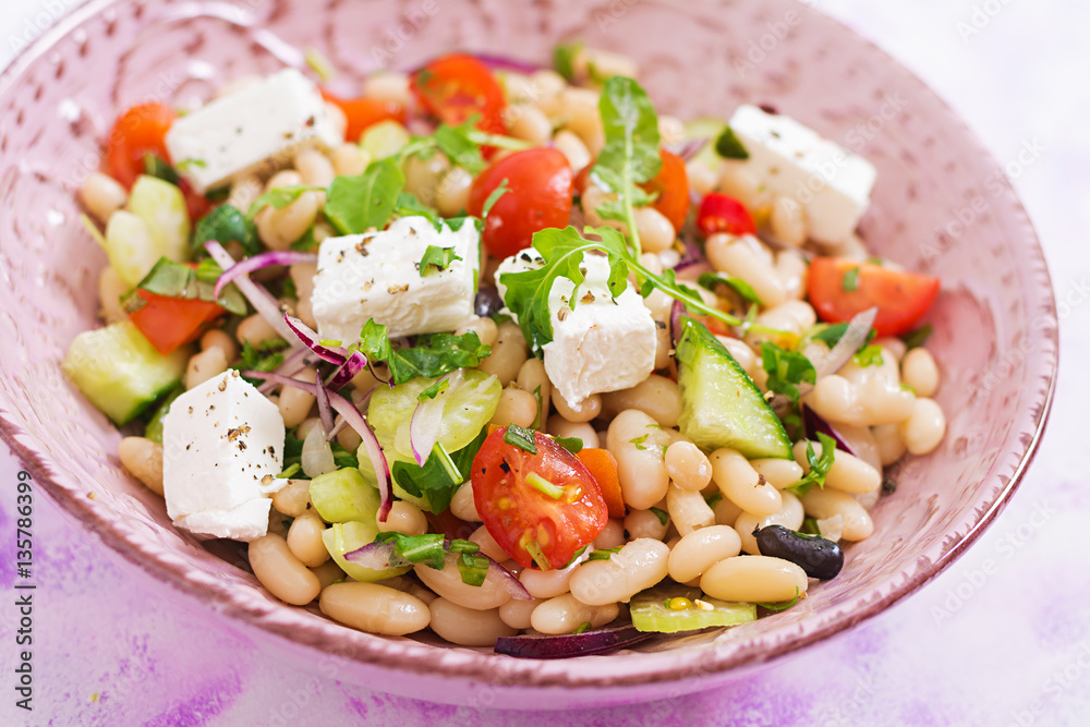 Salad of white beans, tomato, celery, cucumber, arugula, red onion and feta cheese in bowl. Diet food. Healthy lifestyle. Sports nutrition. Salad of white beans, tomato, celery, cucumber, arugula, red onion and feta cheese in bowl. Diet food. Healthy lifestyle. Sports nutrition.