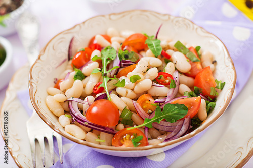 Salad of white beans, tomato, arugula, red onion and pepper in bowl. Diet food. Healthy lifestyle. Sports nutrition.