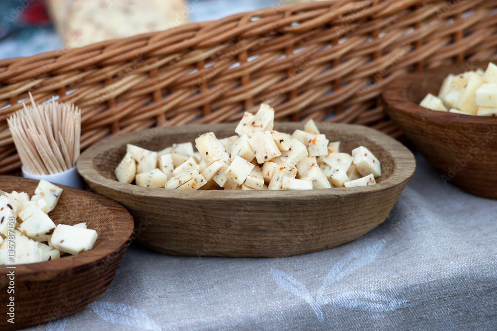 Cheese cubes in a wooden plate Cheese cubes in a wooden plate