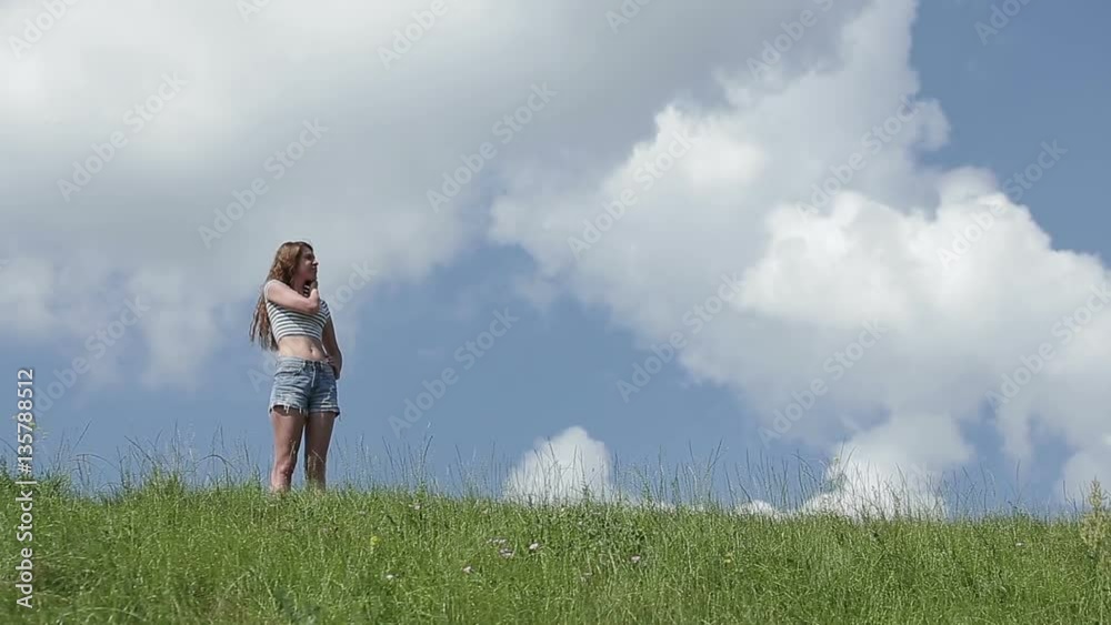 Happy woman in green spring field against blue sky. Freedom and happiness concept Happy woman in green spring field against blue sky. Freedom and happiness concept