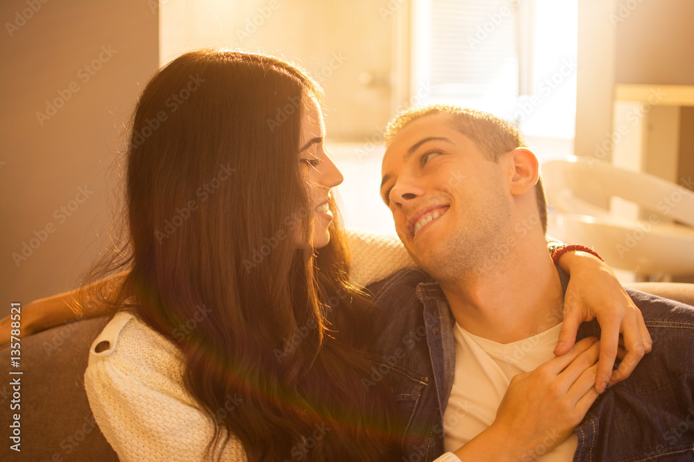 Close up of young woman embracing her boyfriend at home.