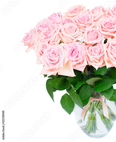 Pink blooming roses bouquet in glass vase close up isolated on white background