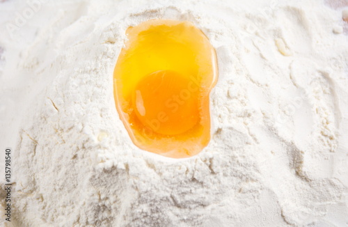 Broken egg on a flour pile