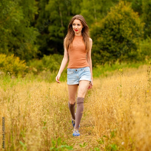 Young beautiful woman walking in a field, summer outdoors © Andrey_Arkusha