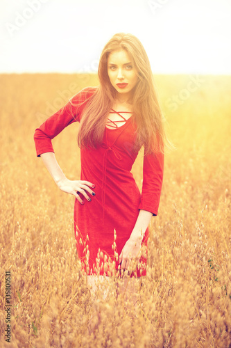 Portrait of a young brunette woman in red dress © Andrey_Arkusha