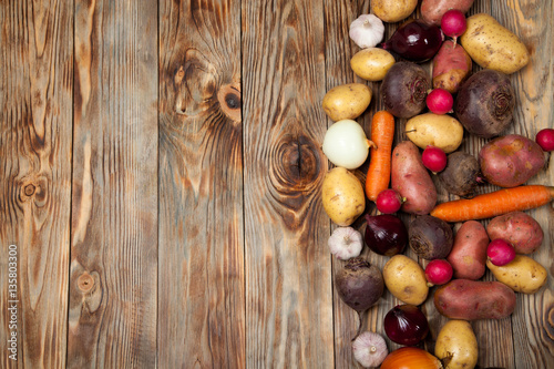 Fototapeta Naklejka Na Ścianę i Meble -  Vegetables. Potatoes, carrots, onions, beets and radishes on a rustic background