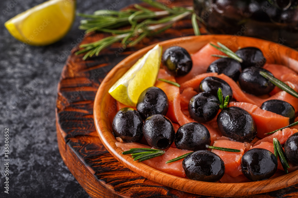Salmon with olives and lime on a wooden board. Salmon with olives and lime on a wooden board.