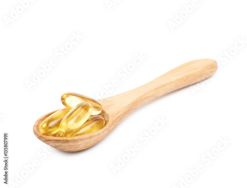 Wooden spoon full of softgel pills