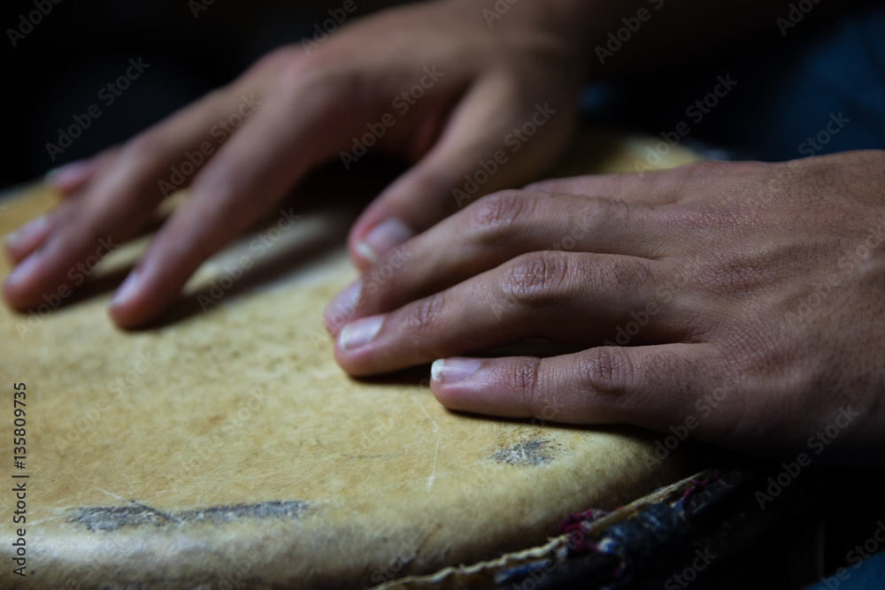 Playing African Drums in Low Key Single Light by Musician in Mus Playing African Drums in Low Key Single Light by Musician in Mus