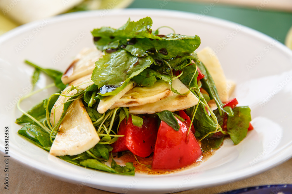 Salad with spinach, tomatoes and grilled cheese lie t on the pla Salad with spinach, tomatoes and grilled cheese lie t on the pla