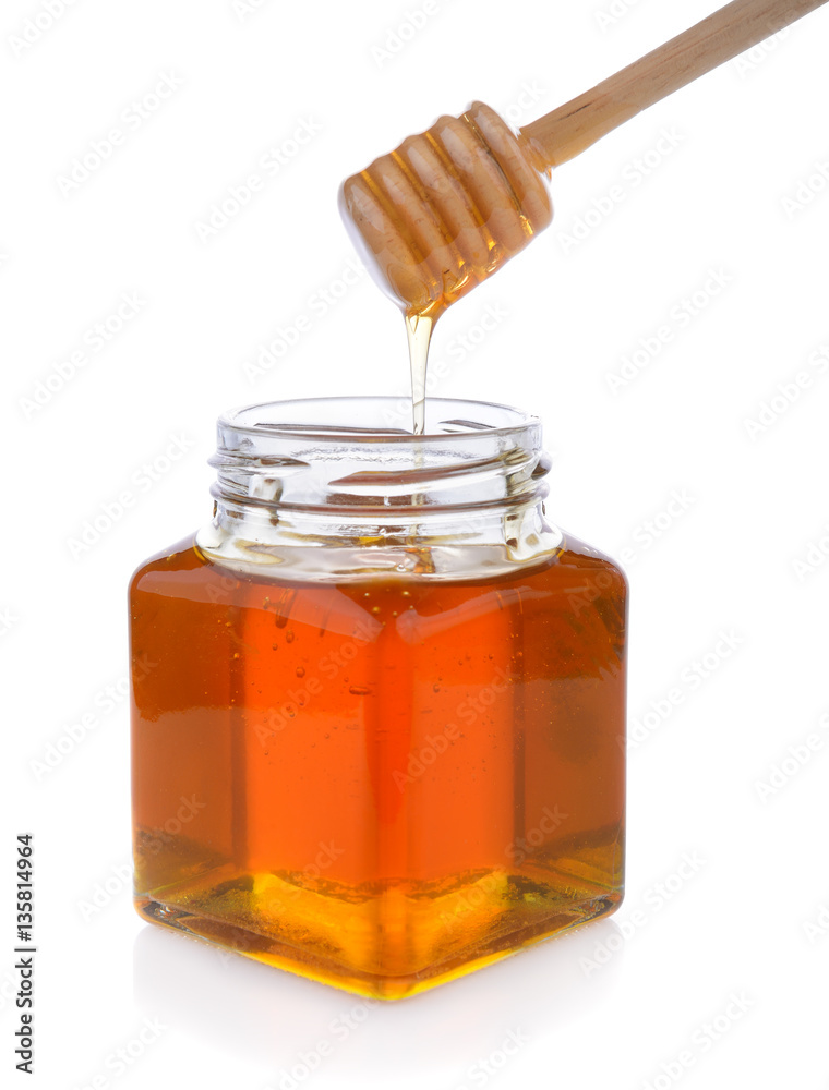Honey with wooden honey dipper on jar Honey with wooden honey dipper on jar