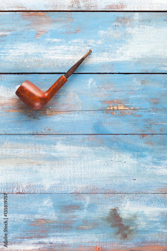 Saddle-stemmed Billiard Pipe on a blue wooden table, old smoke pipe Saddle-stemmed Billiard Pipe on a blue wooden table, old smoke pipe
