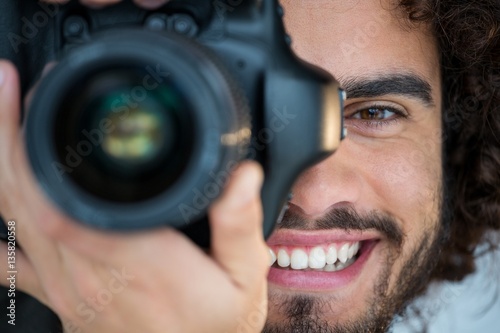 Canvas Print Happy male photographer with digital camera in studio