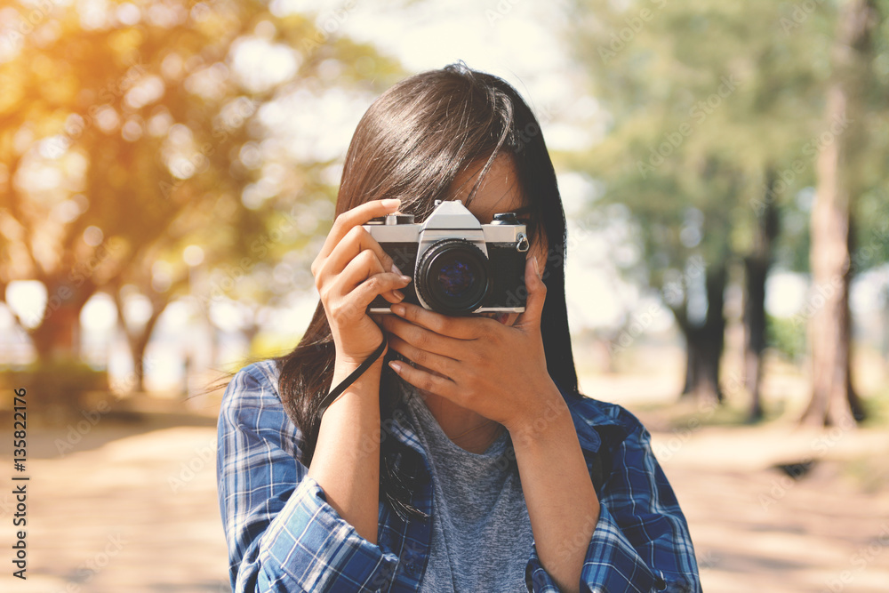 Asian women holding a camera in nature and relax time on holiday.concept travel color of vintage tone Asian women holding a camera in nature and relax time on holiday.concept travel color of vintage tone