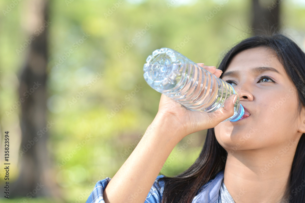 Asian women drinking water in nature and relax time on holiday.concept travel color of vintage tone selective and soft focus Asian women drinking water in nature and relax time on holiday.concept travel color of vintage tone selective and soft focus