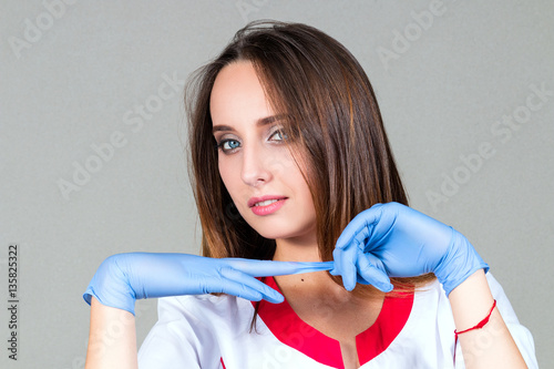 hands and face of a woman doctor Close-up, remove sterile gloves isolated on a light background
