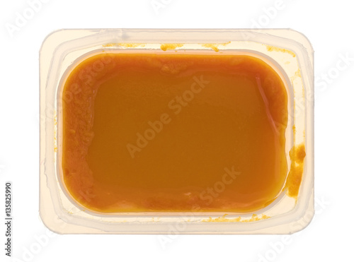 Baby food in a plastic container top view isolated on a white background. © Bert Folsom