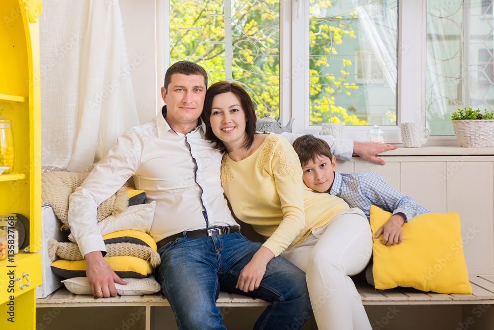 happy family sitting near large window happy family sitting near large window