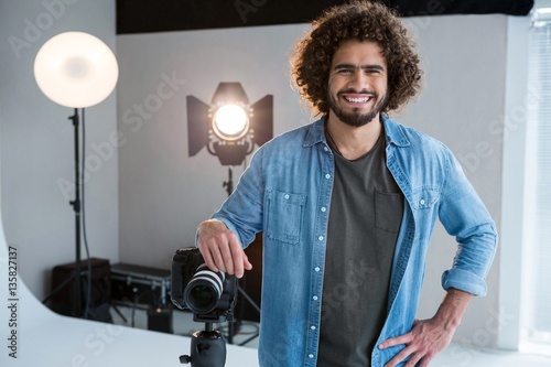 Happy male photographer standing in studio photo