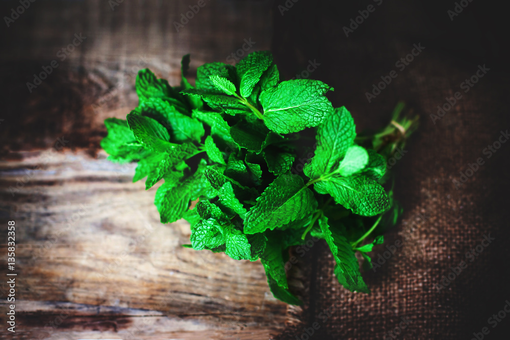 Fresh mint leaves herb on wooden table, selective focus close up Fresh mint leaves herb on wooden table, selective focus close up