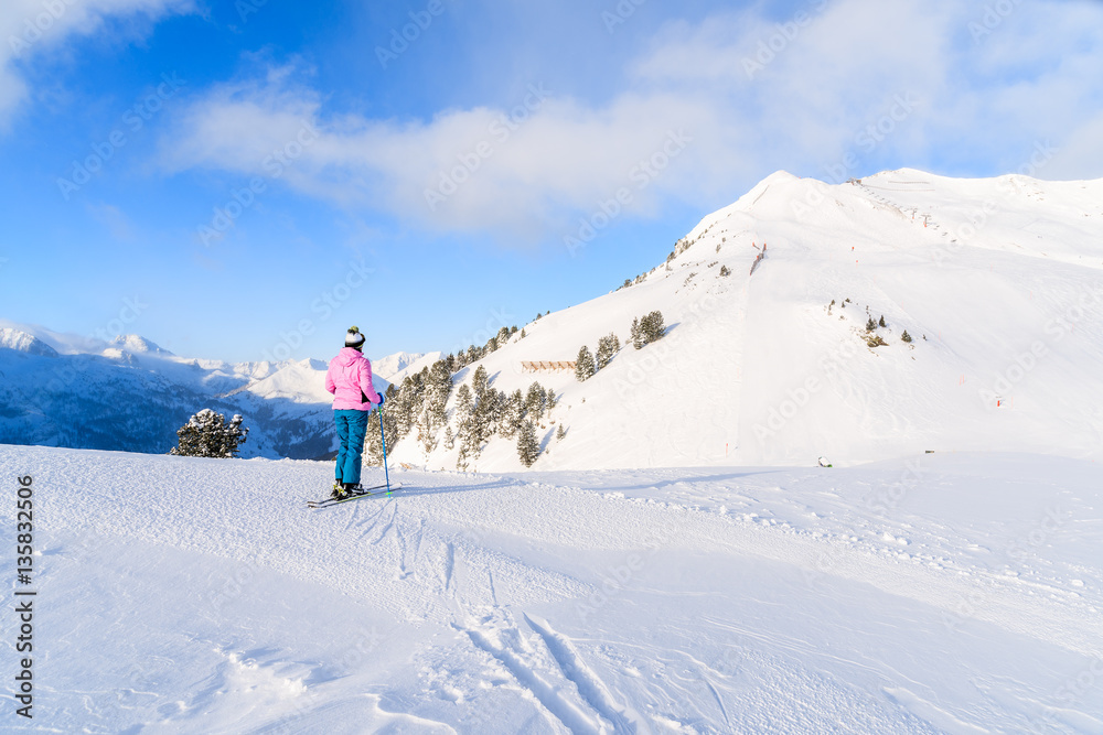 Young woman skier looking at mountains in Obertauern ski area, Austria