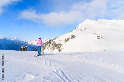 Young woman skier looking at mountains in Obertauern ski area, Austria